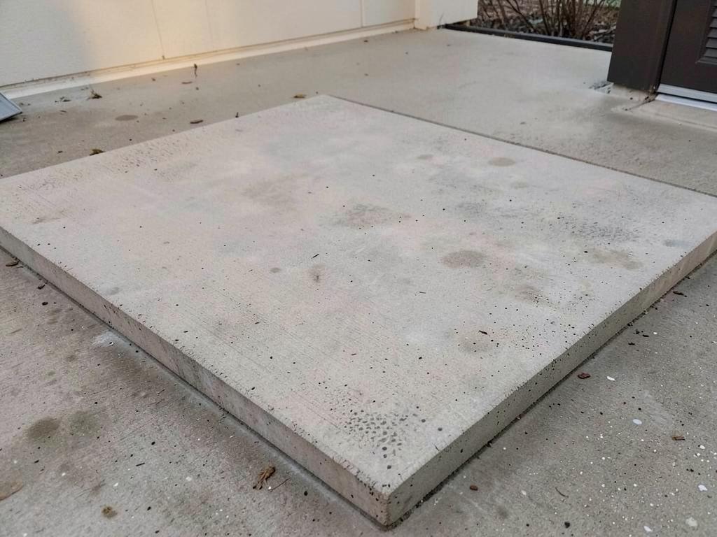 Broom-finished concrete patio slab with straight formed edges and visible aggregate grain